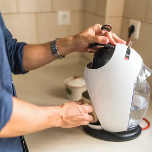 close-up-man-holding-coffee-mug-capsule-espresso-coffee-maker